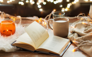 A candle, a an open book, a cup of coffee, autumn vibe background