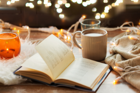 A candle, a an open book, a cup of coffee, autumn vibe background