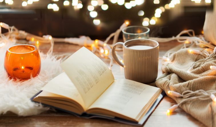 A candle, a an open book, a cup of coffee, autumn vibe background