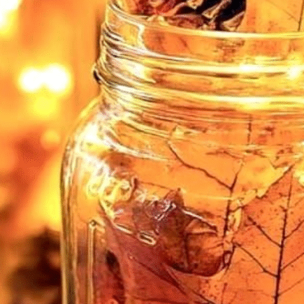 A candle with autumn leaves